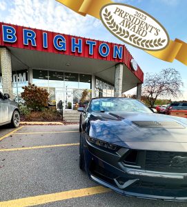 Ford Mustand in front of Brighton Ford in Brighton, Michigan with the President's Award logo and ribbon.